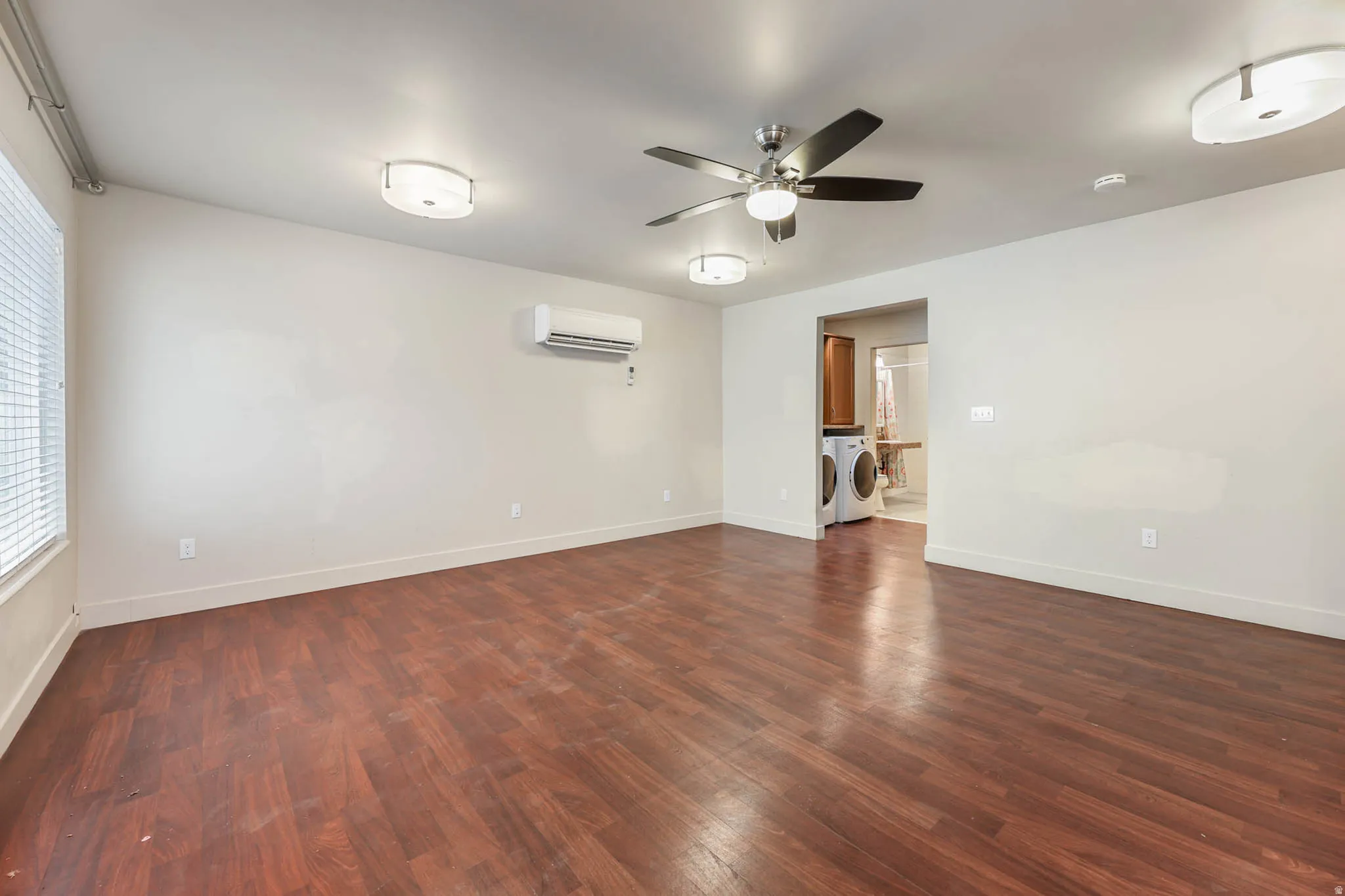 UNIT #1 Unfurnished room featuring dark wood-type flooring, a ceiling fan, and washer / clothes dryer