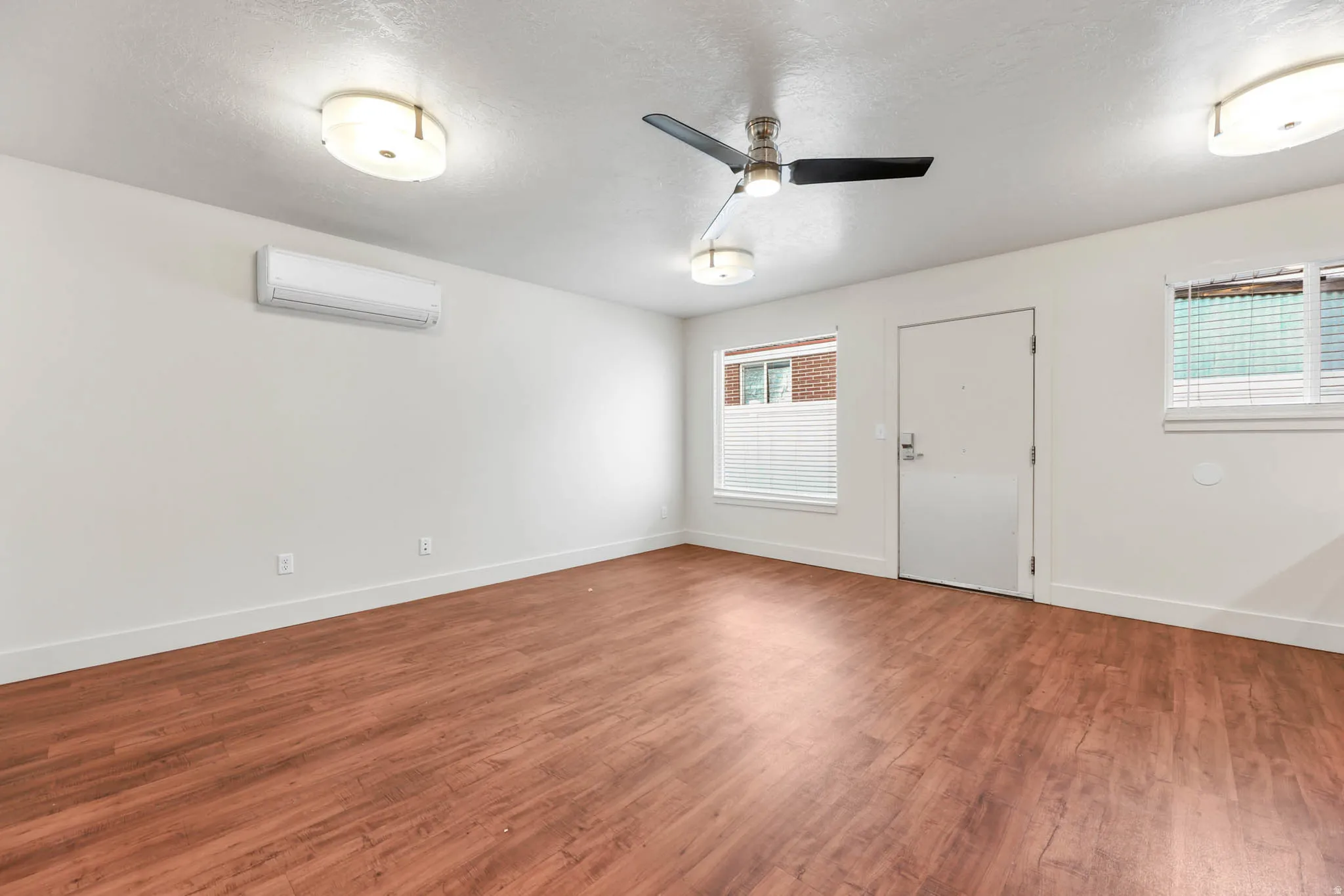 UNIT #2 Unfurnished room featuring wood finished floors, ceiling fan, and a textured ceiling
