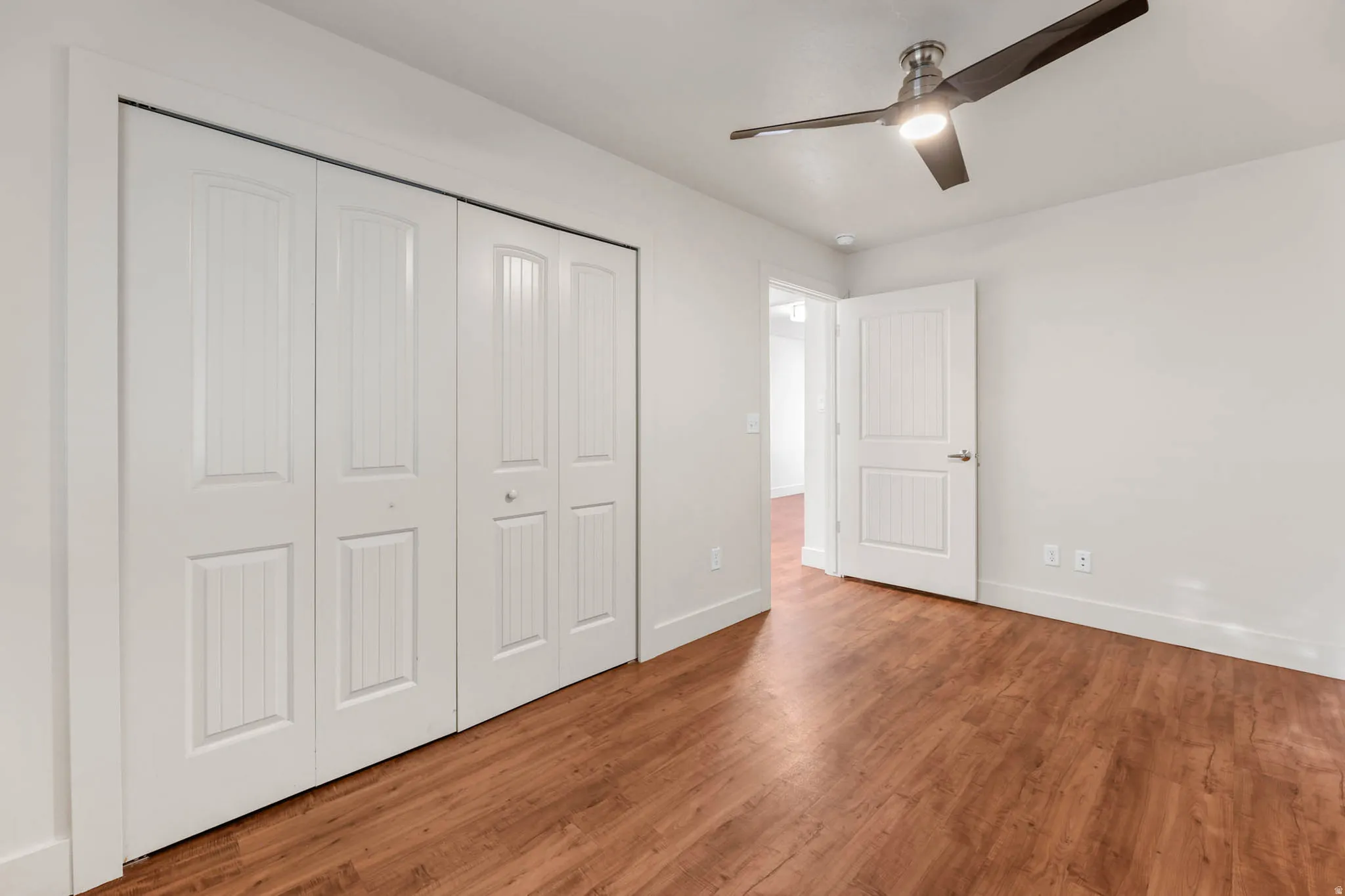 UNIT #2 Unfurnished bedroom with a closet, wood finished floors, and ceiling fan