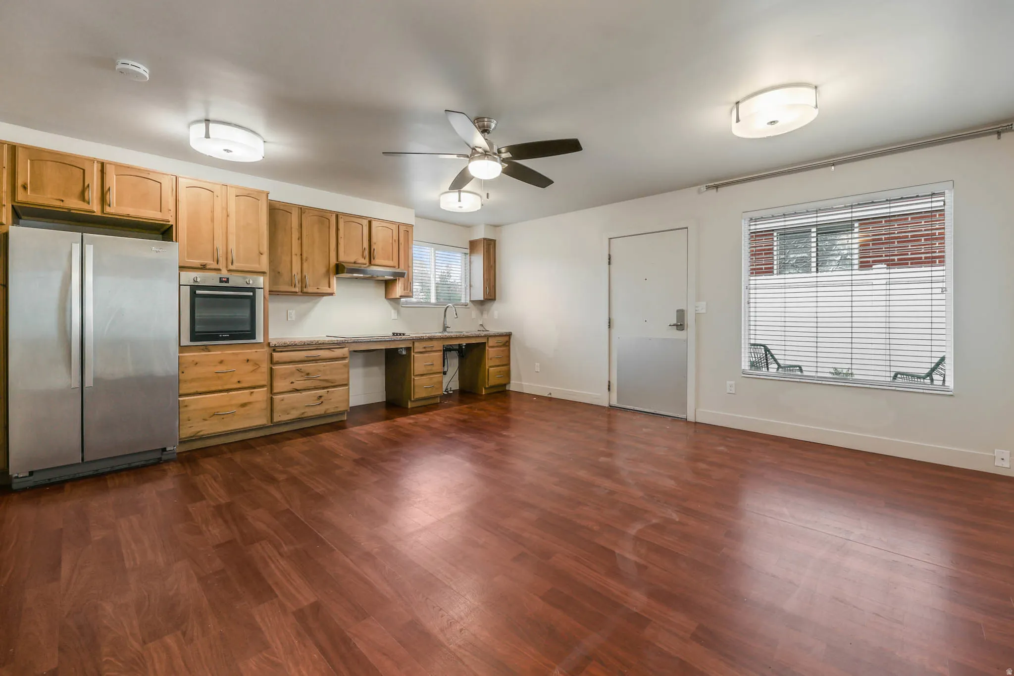 UNIT #1 Kitchen featuring stainless steel appliances, light countertops, a ceiling fan, dark wood-style floors, and light wood finish cabinets