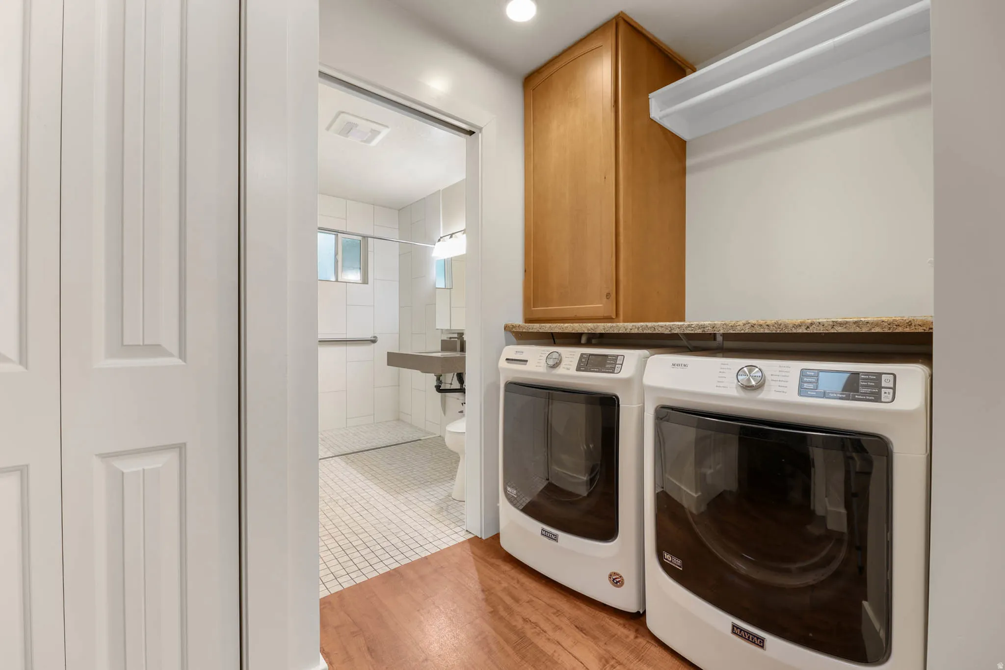 UNIT #2  Laundry room featuring separate washer and dryer, light wood finished floors, recessed lighting, and cabinet space