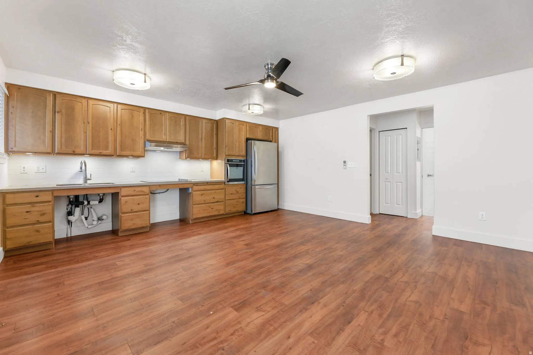 UNIT #2 Kitchen with ceiling fan, light countertops, stainless steel appliances, dark wood finished floors, and tasteful backsplash