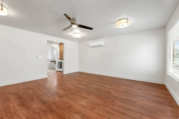UNIT #2 Empty room featuring ceiling fan and dark wood-style floors