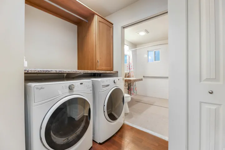 UNIT #1 Laundry area featuring separate washer and dryer and wood finished floors