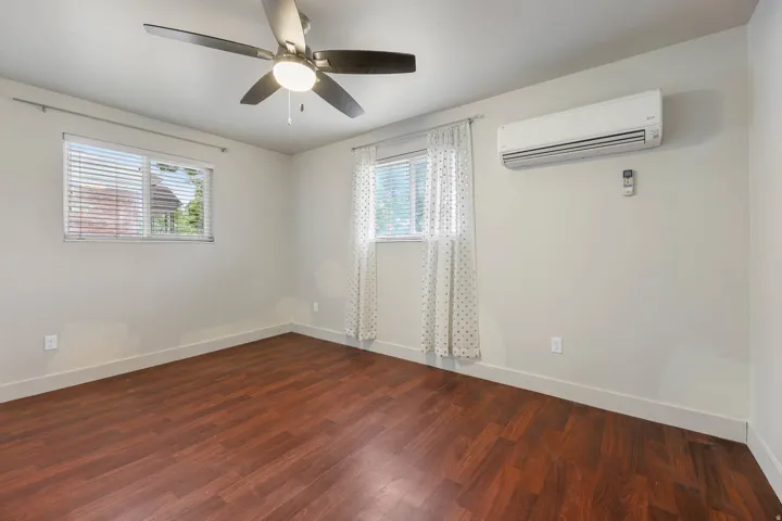 UNIT #1 Spare room with dark wood-style flooring and ceiling fan