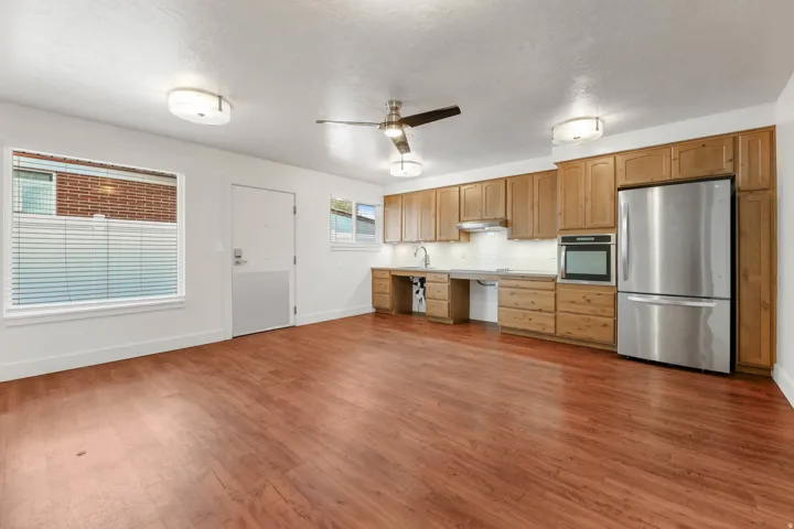 UNIT #2 Kitchen featuring stainless steel appliances, ceiling fan, light countertops, dark wood-style floors, and decorative backsplash