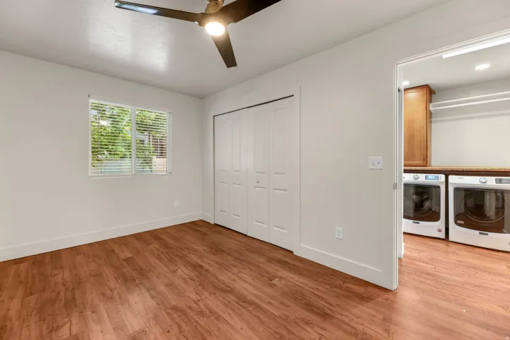 UNIT #2 Unfurnished bedroom with light wood-style floors, a closet, ceiling fan, and independent washer and dryer