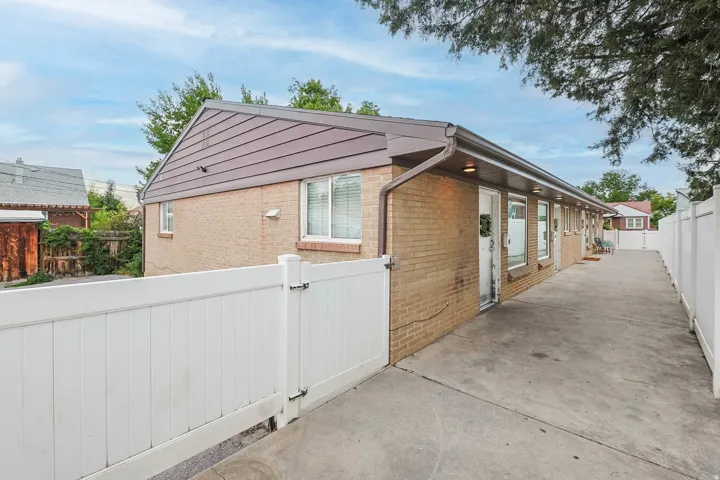 View of property exterior with brick siding and a gate