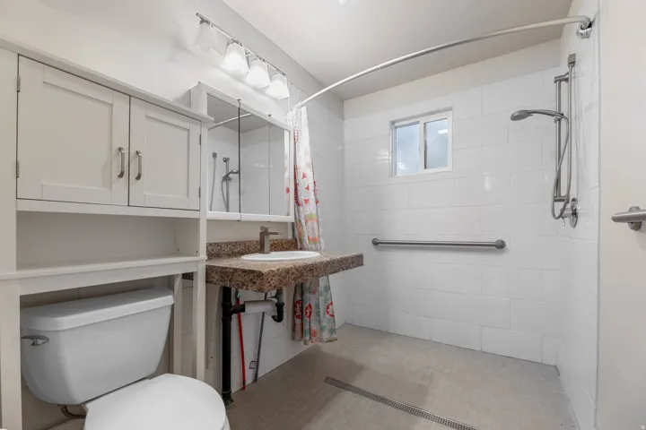 UNIT #1 Bathroom with vanity and a tile shower