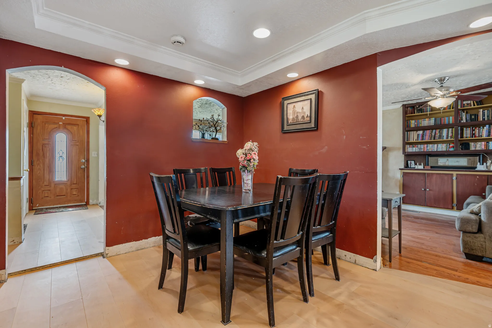 Dining space with ceiling fan, arched walkways, recessed lighting, crown molding, and light wood-style flooring