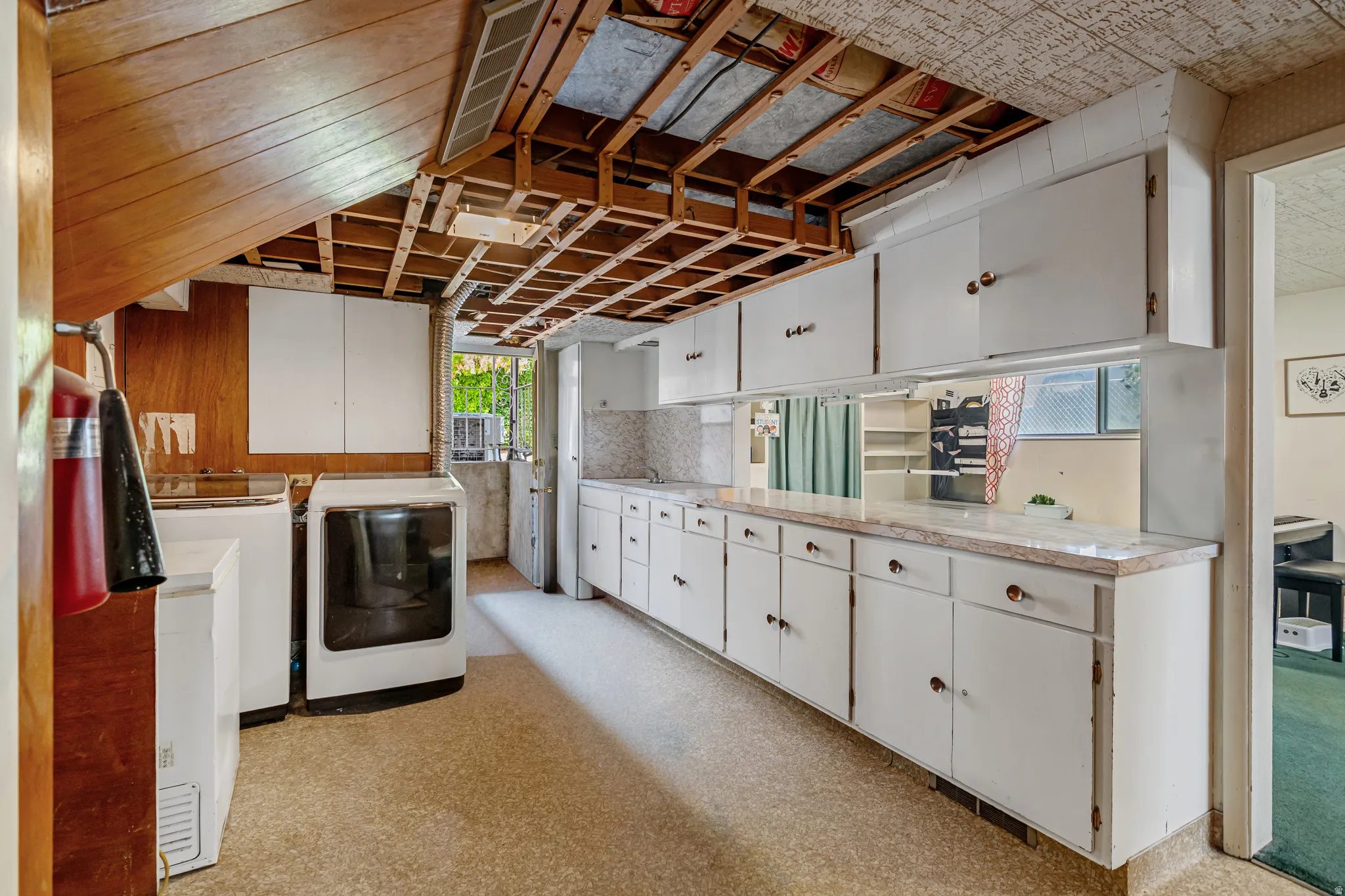 Laundry area featuring light flooring, washer and clothes dryer, and cabinet space