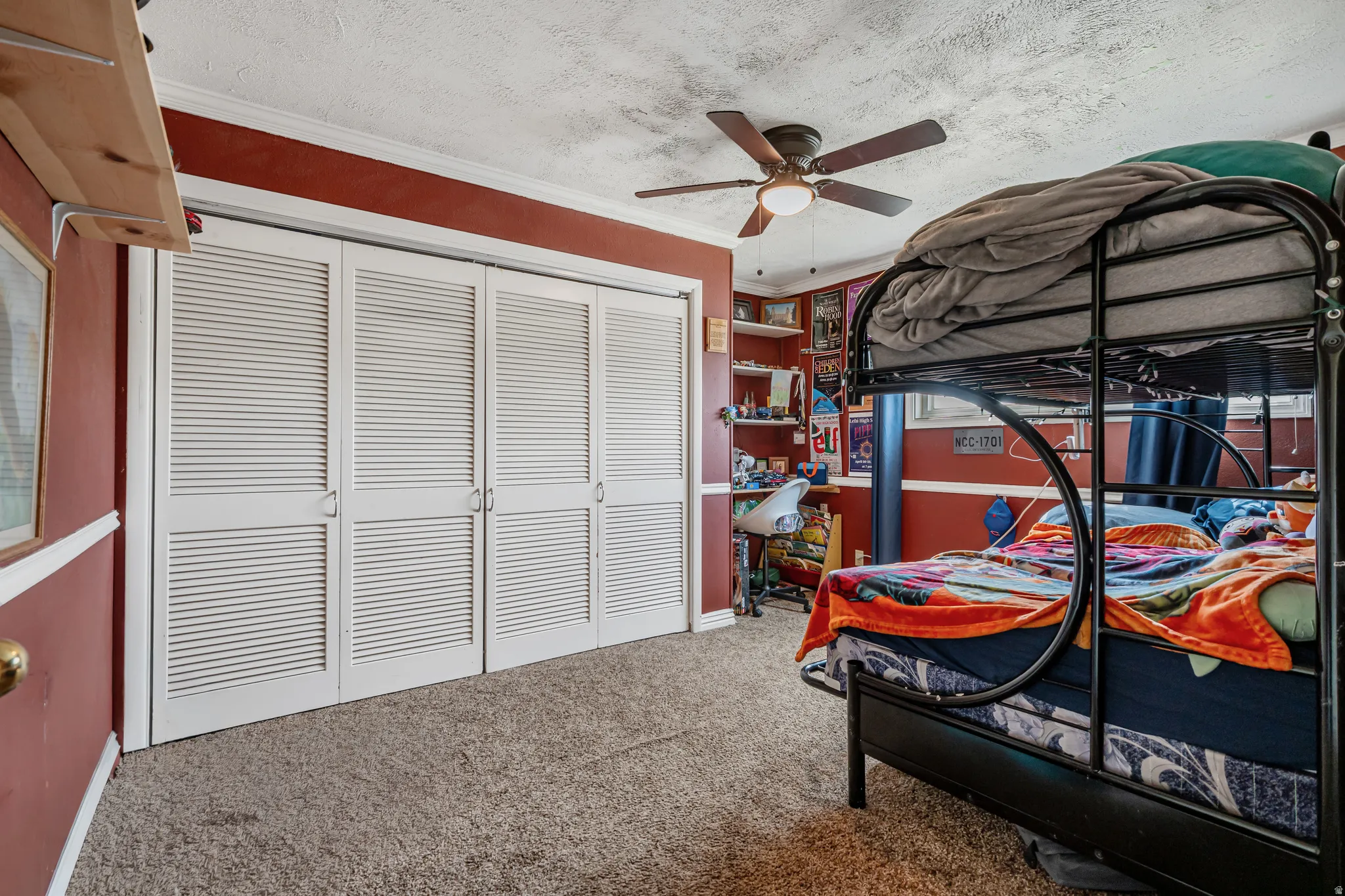 Bedroom with a closet, crown molding, light carpet, a ceiling fan, and a textured ceiling