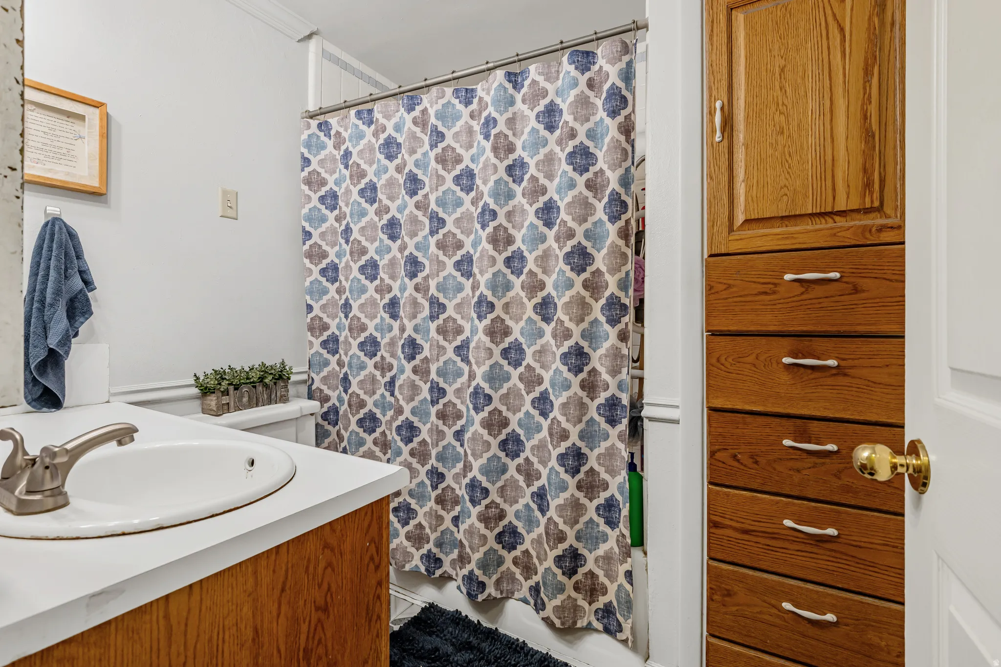 Bathroom featuring a shower with shower curtain and vanity