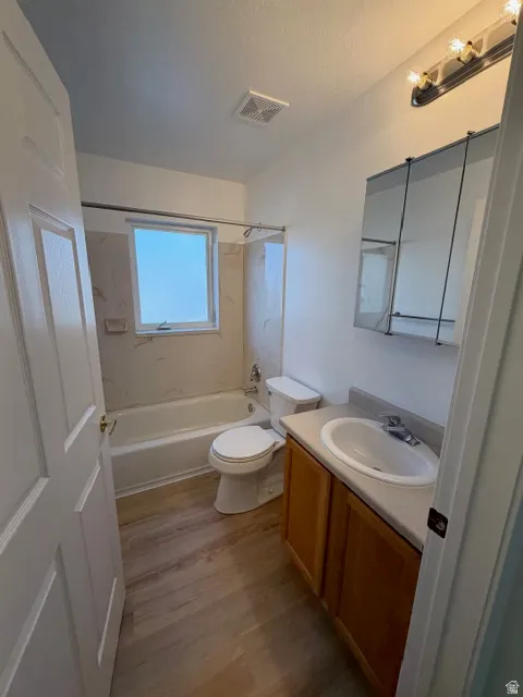 Full bath featuring vanity, shower / bathtub combination, and light wood finished floors