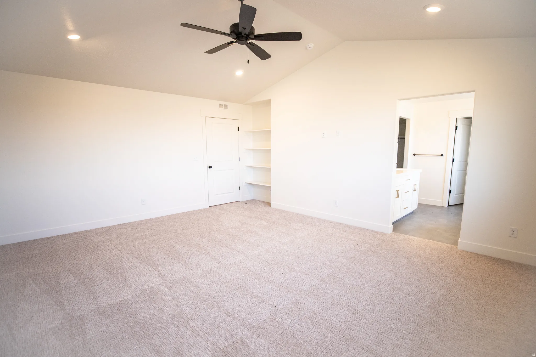 Primary bedroom with vaulted ceilings, recessed lighting, and a ceiling fan