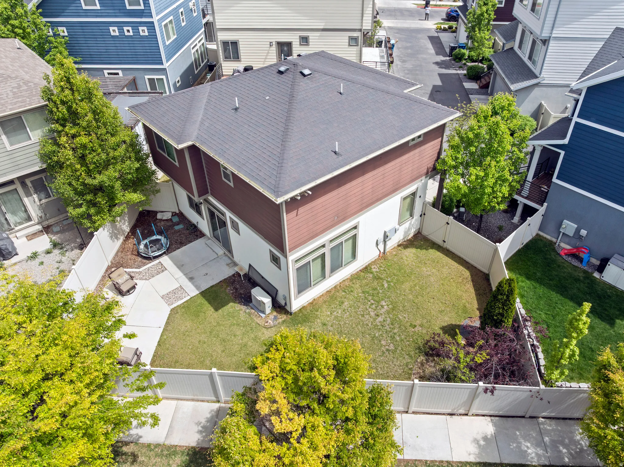 Two-story property with a dark shingled roof and brown and white siding. NO NEIGHBORS in back of you.
