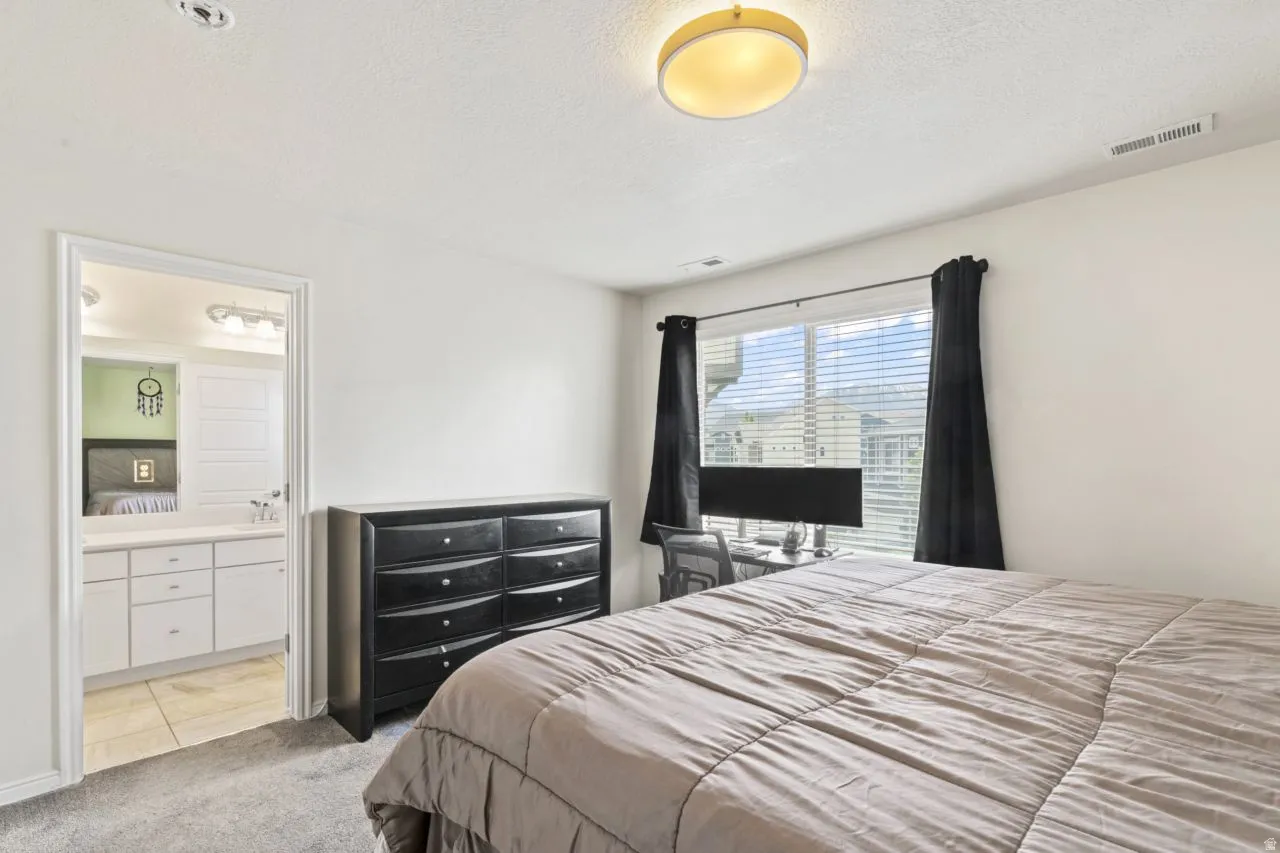Bedroom featuring light carpet and a textured ceiling