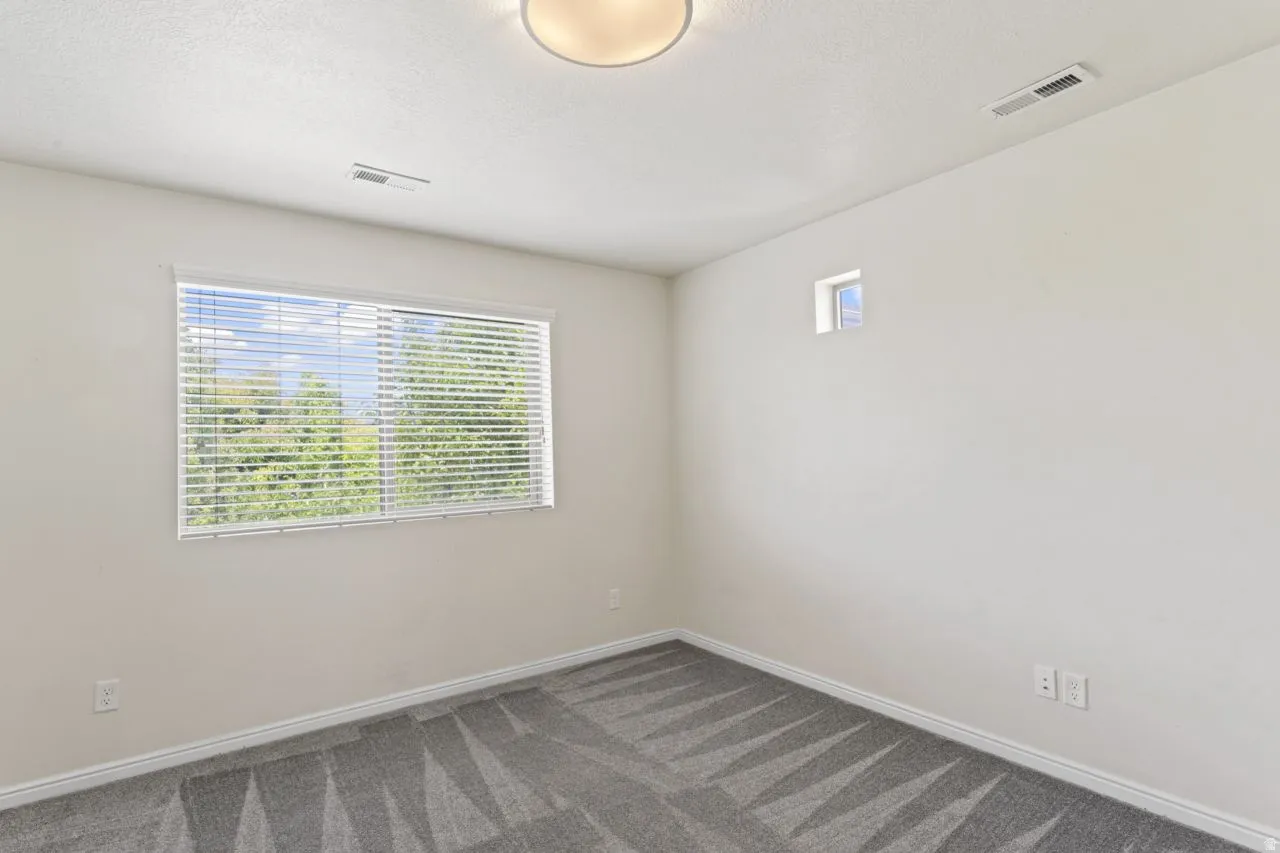 Spare room featuring dark carpet and a textured ceiling