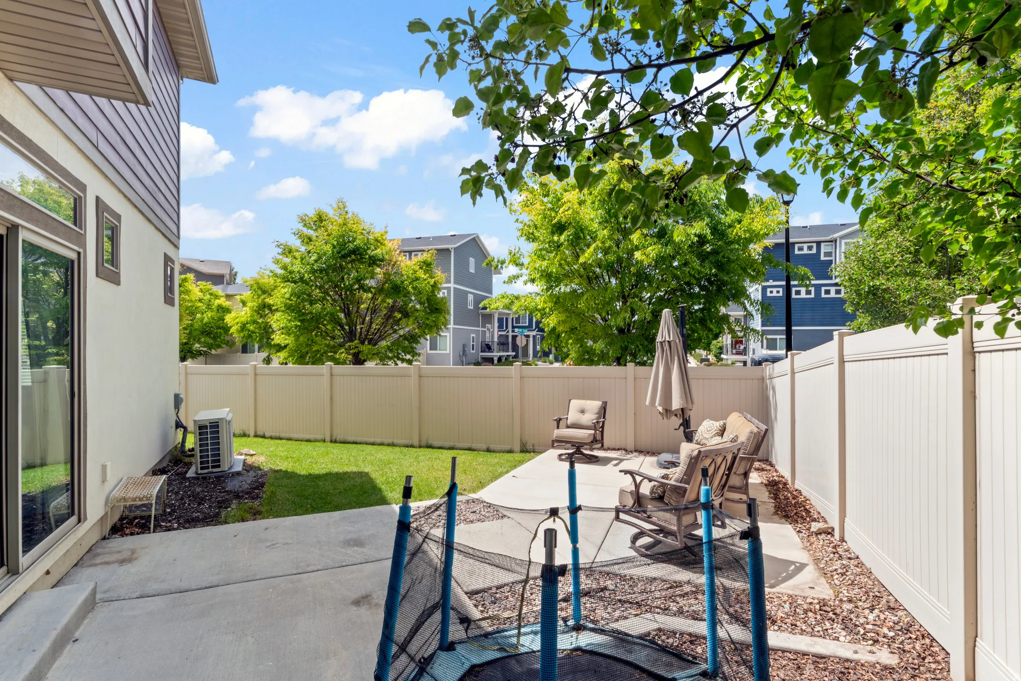 Private backyard featuring a concrete patio and a manicured lawn