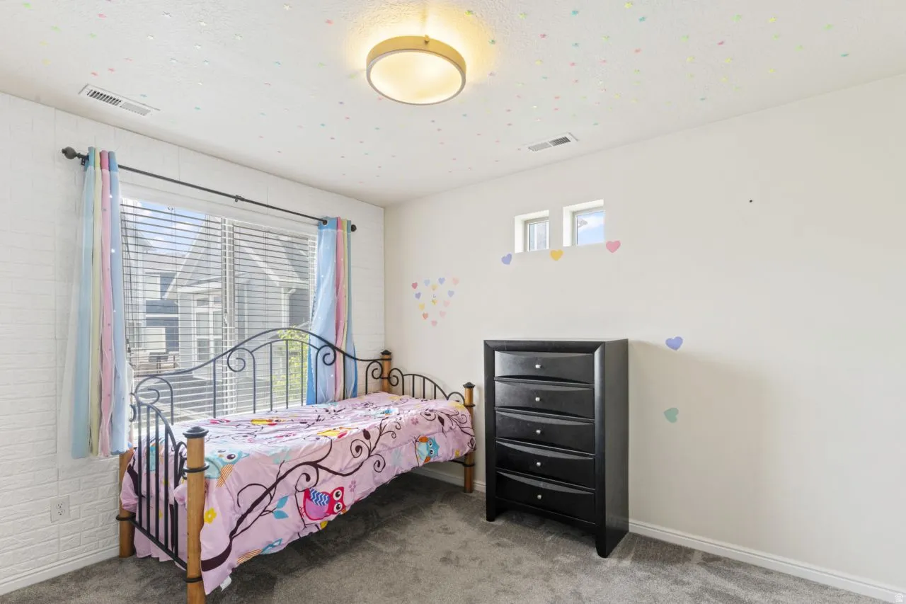 Bedroom with light colored carpet and baseboards