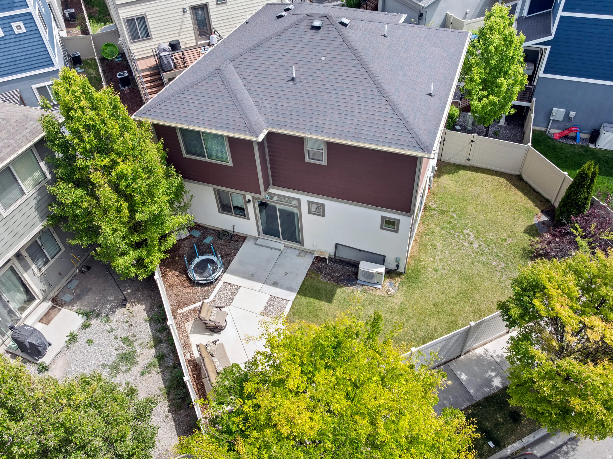 Rear exterior featuring a two-story design with a dark shingle roof, brown siding, and light-colored lower-level siding