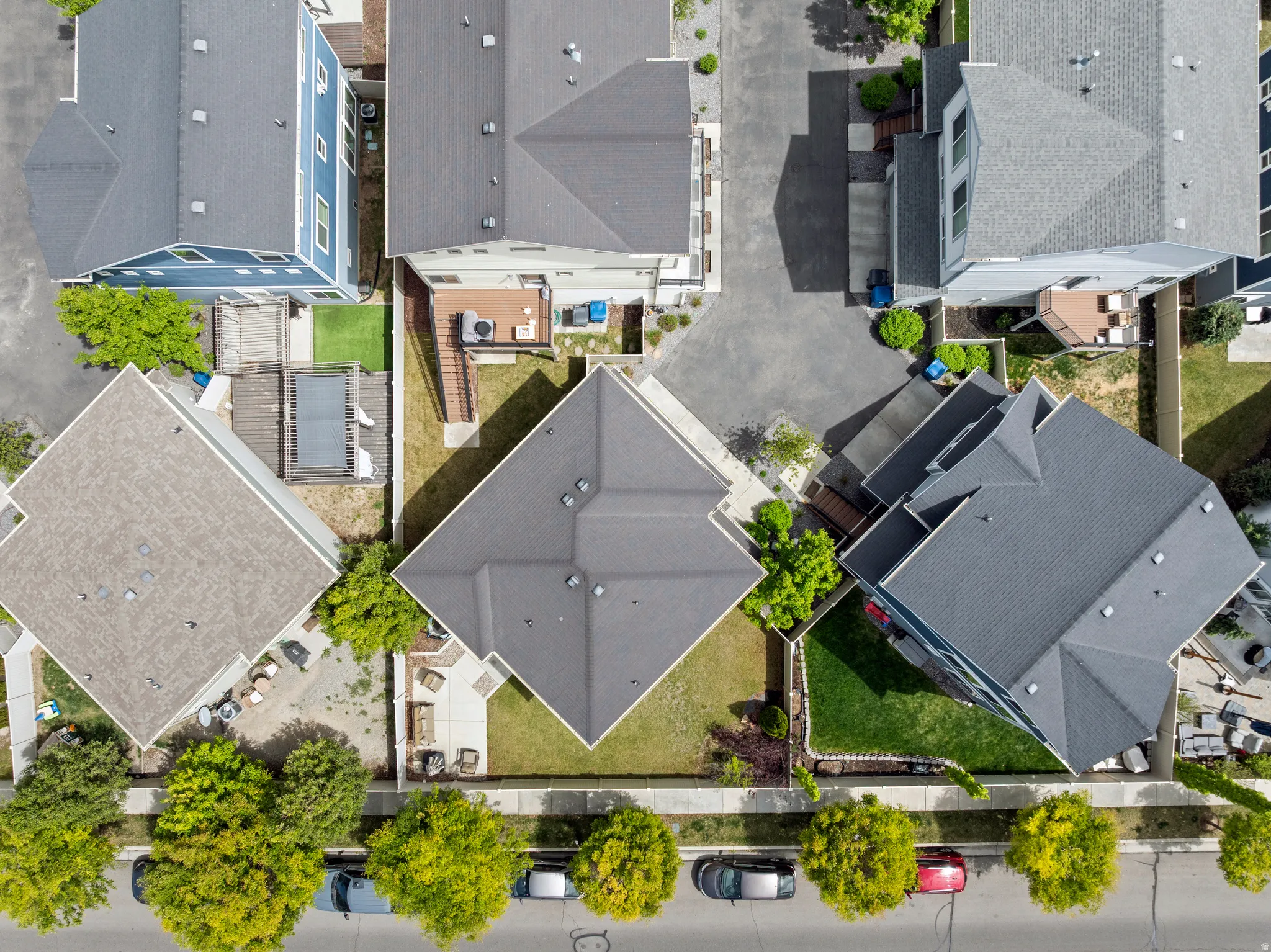 Aerial perspective showcasing multiple properties with dark gray asphalt shingle roofs