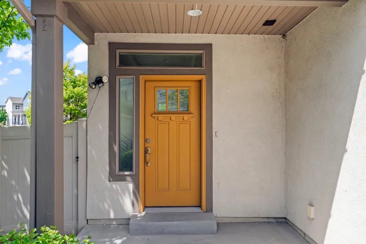 Inviting entryway featuring a warm wood-finish front door with glass panels, complemented by a transom window and a sidelight window