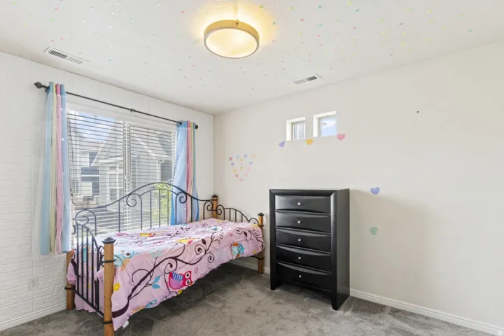 Bedroom with light colored carpet and baseboards