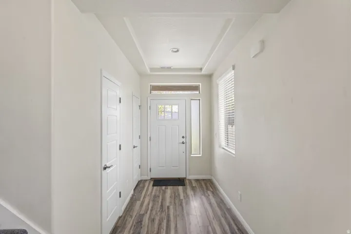 Doorway to outside featuring wood finished floors and a tray ceiling