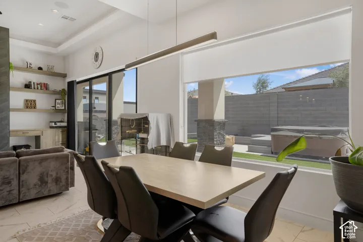 Dining space with light marble finish flooring and a raised ceiling