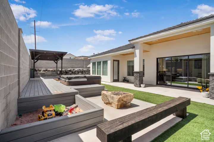 Wooden terrace with a hot tub, a fenced backyard, and a patio