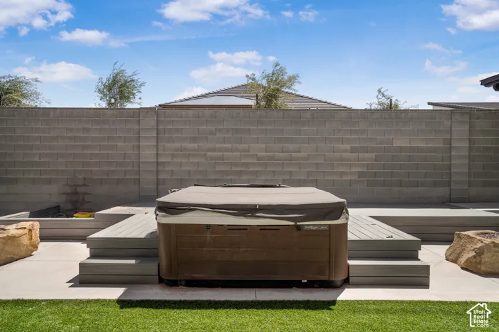 Fenced backyard with a hot tub and a patio area
