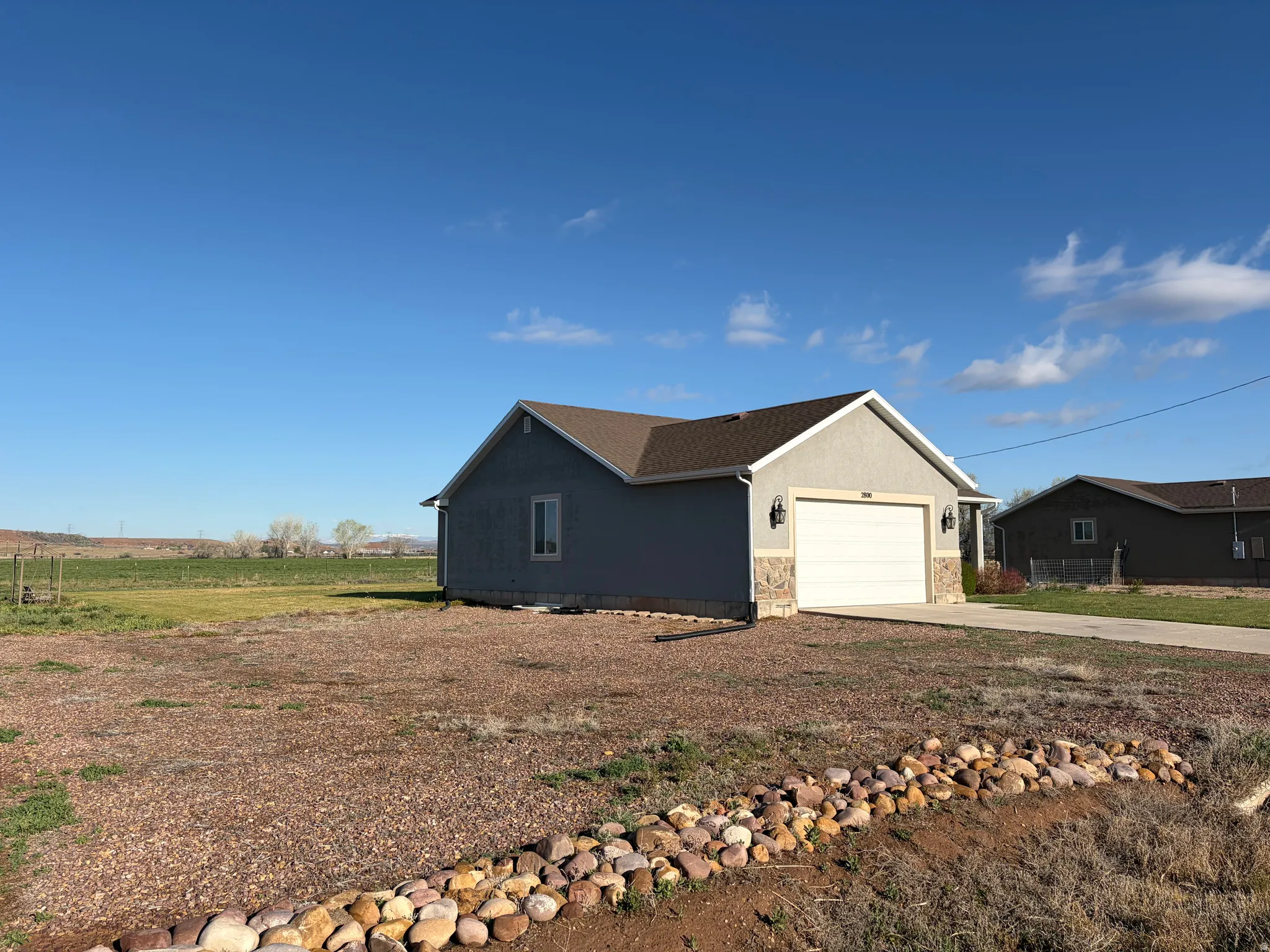 View of side of home with concrete driveway, an attached garage, and stucco siding