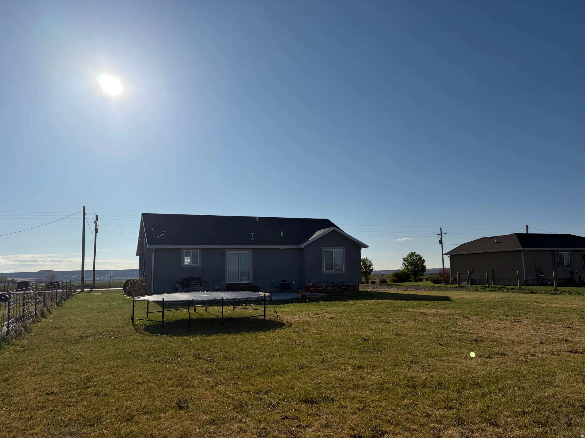 Back of property featuring a trampoline and a patio area