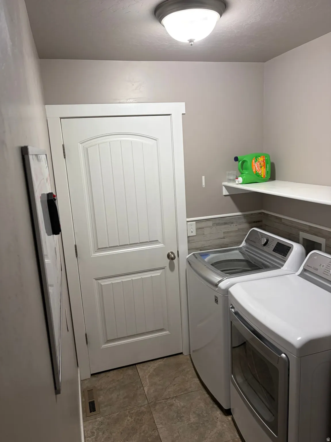 Laundry room featuring separate washer and dryer and a textured ceiling