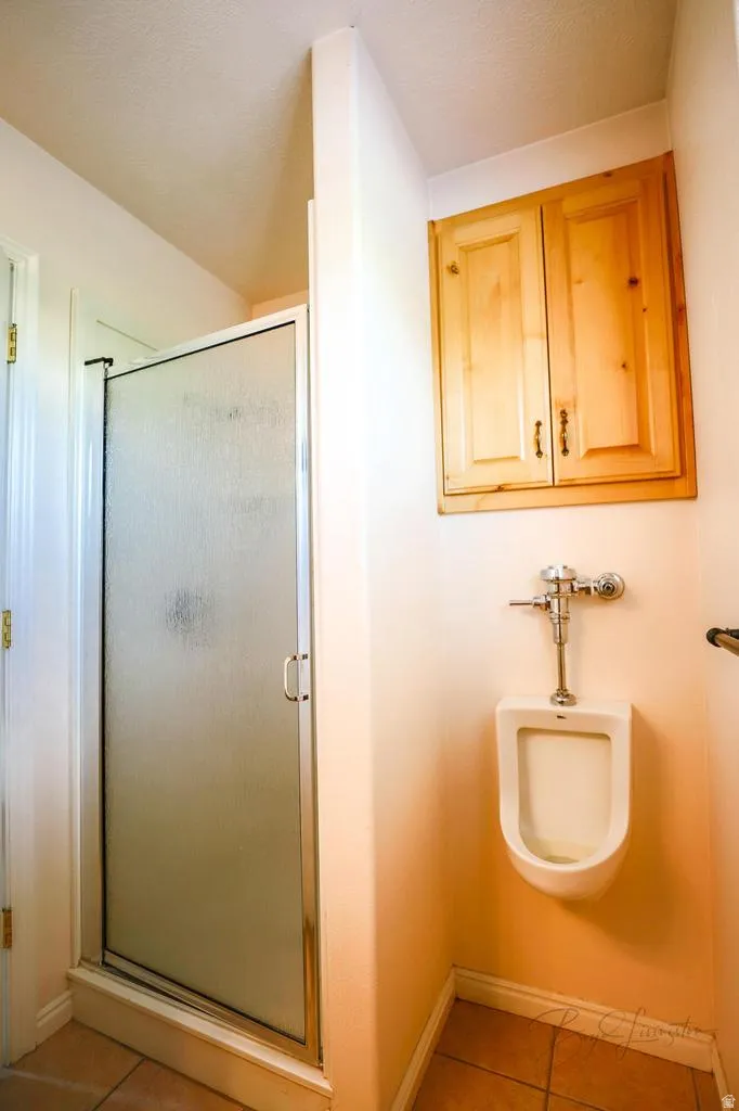 Bathroom with light tile patterned floors and a stall shower