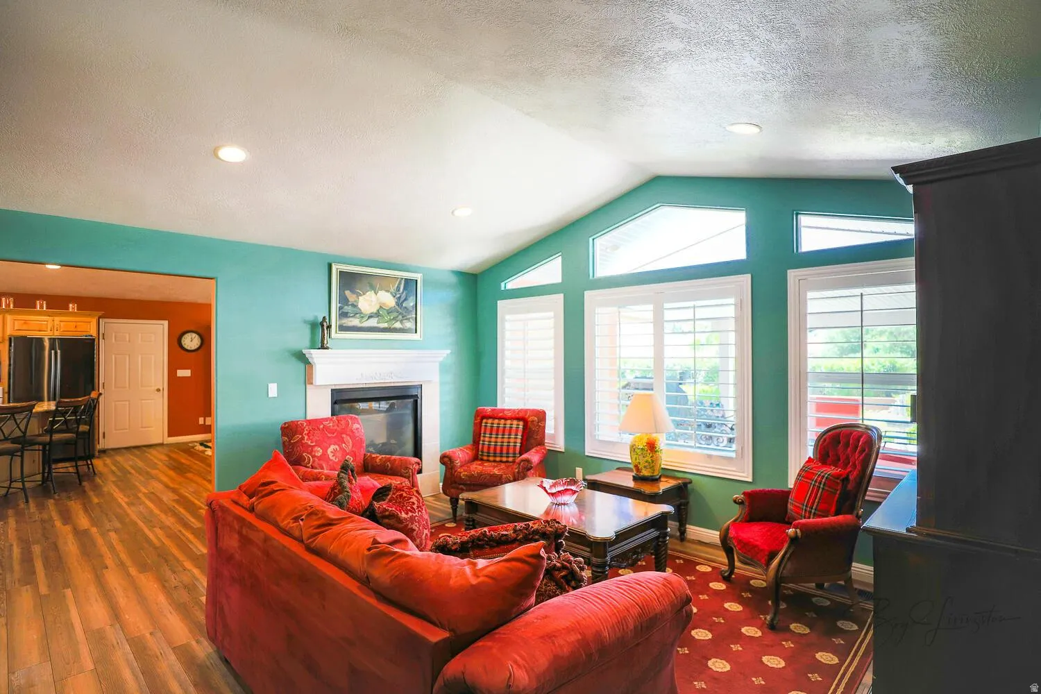 Living area featuring a glass covered fireplace, dark wood-style floors, recessed lighting, and a textured ceiling