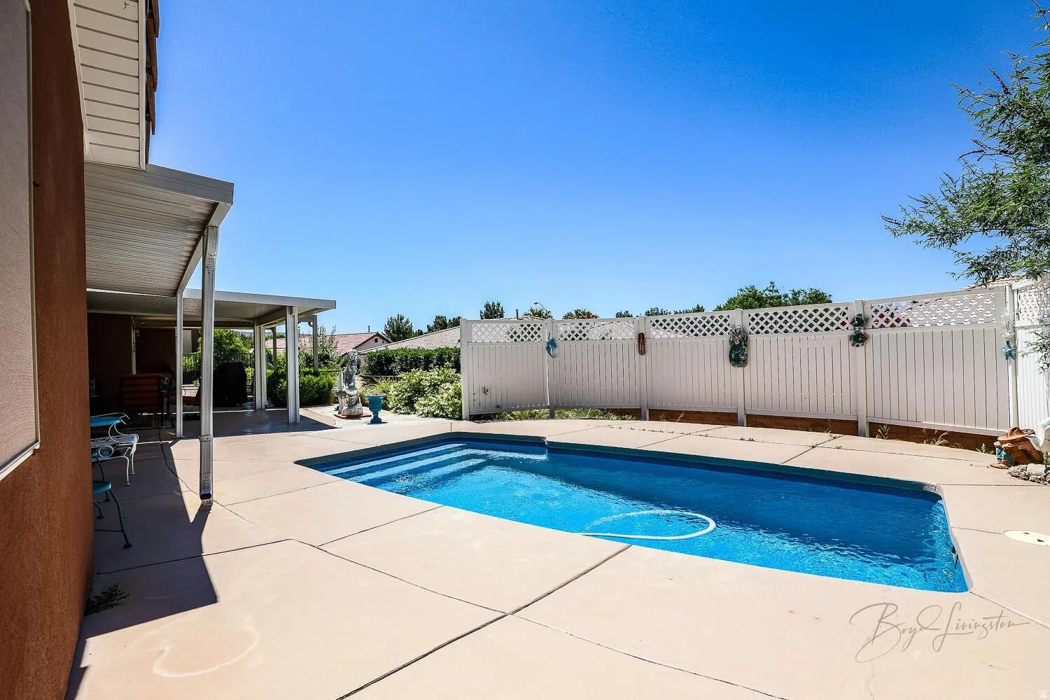 View of pool with patio surround and a fenced backyard