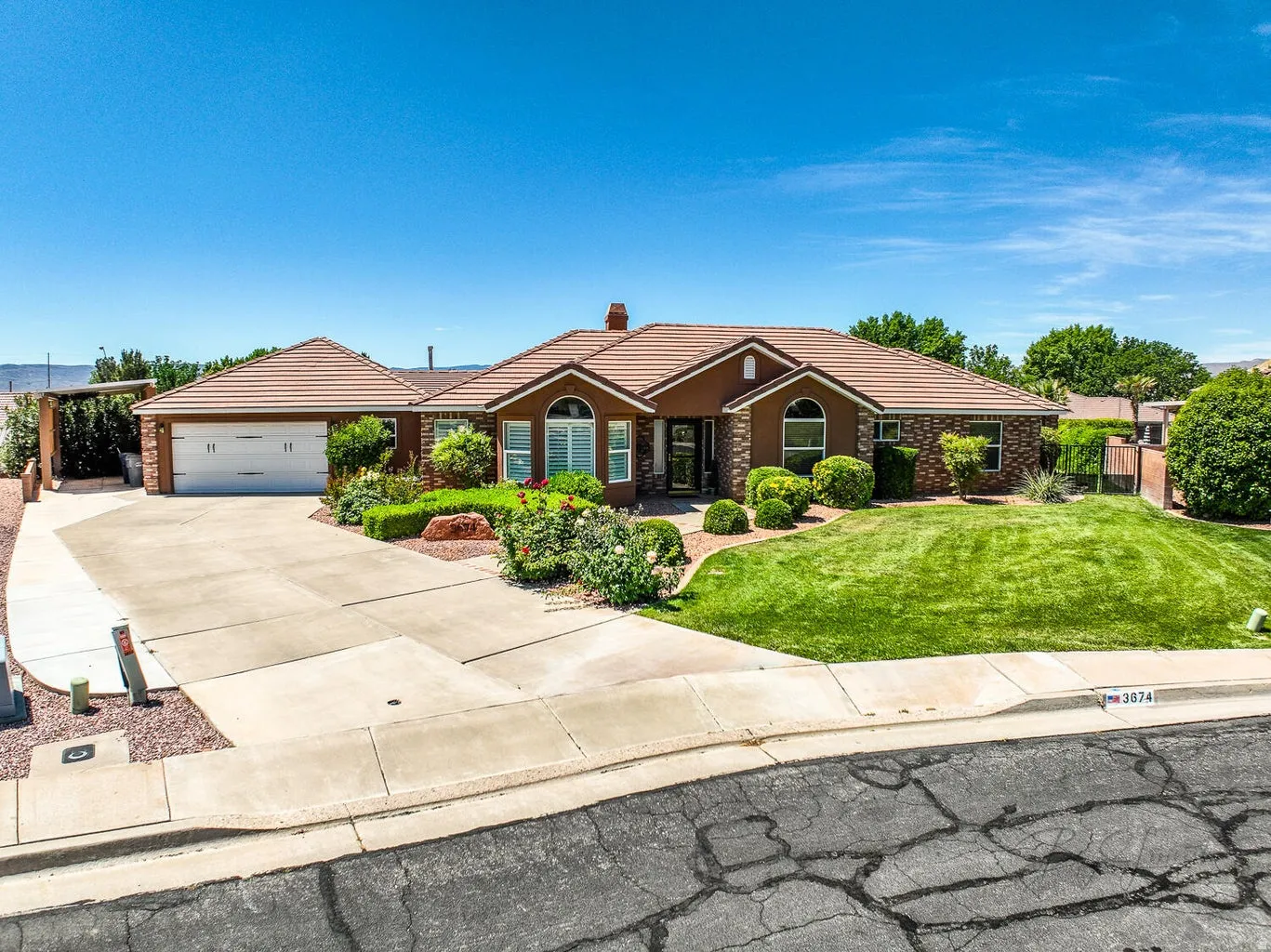 Single-story residence featuring a tile roof and a concrete driveway