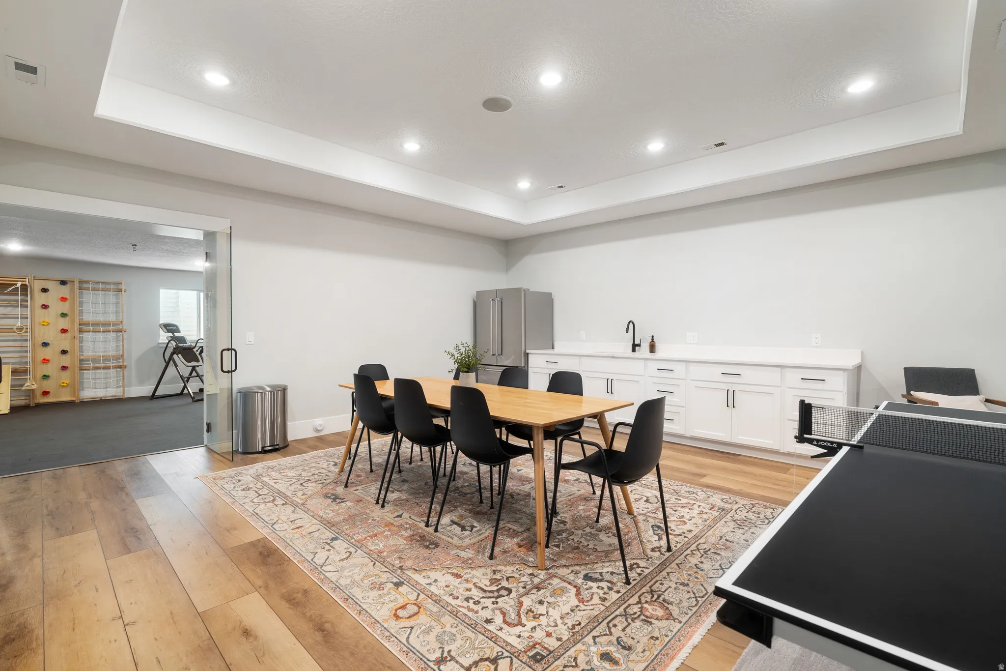 Dining space featuring a tray ceiling, recessed lighting, and light wood-style flooring
