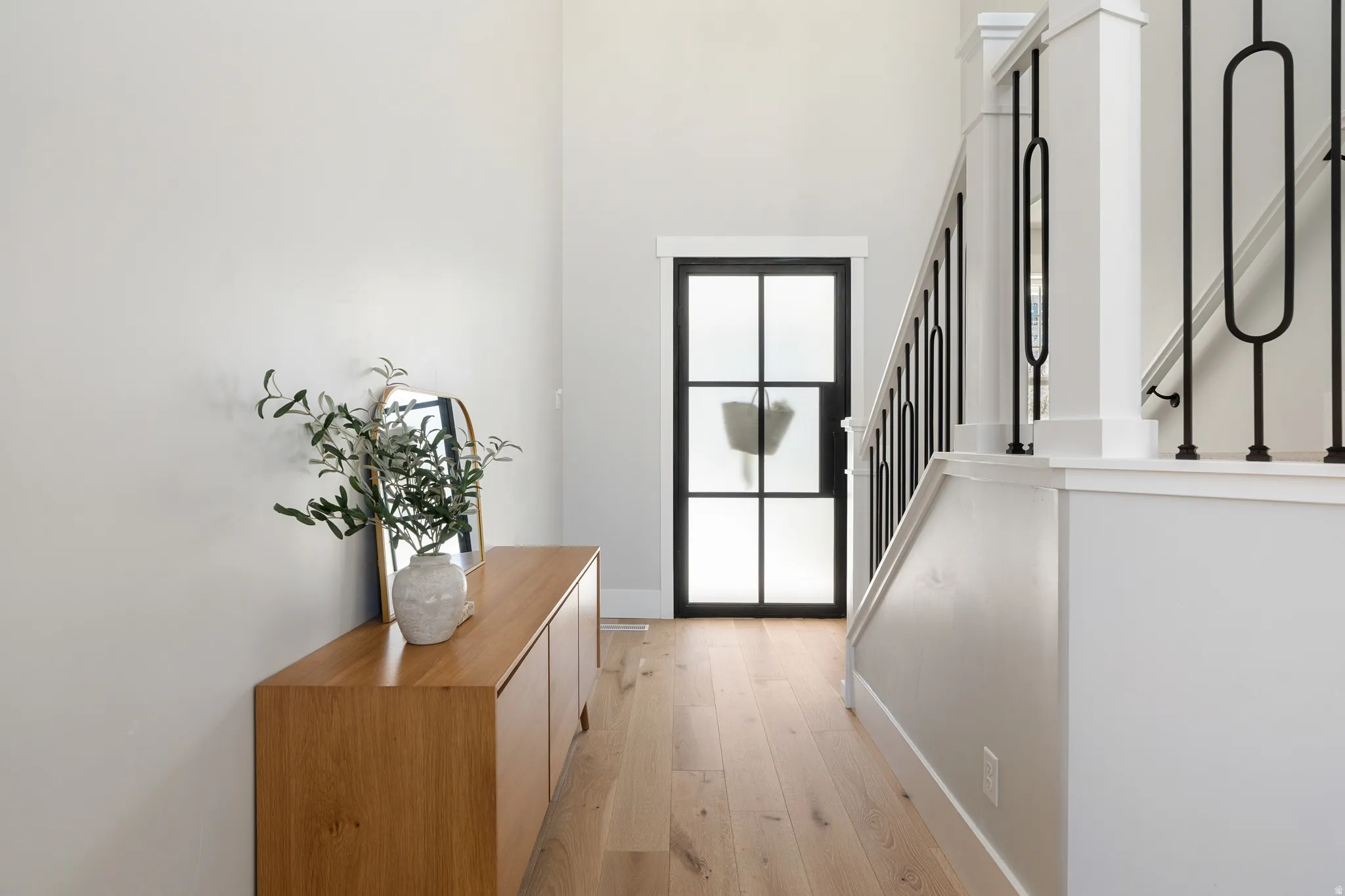 Entryway with wood-type flooring and a high ceiling