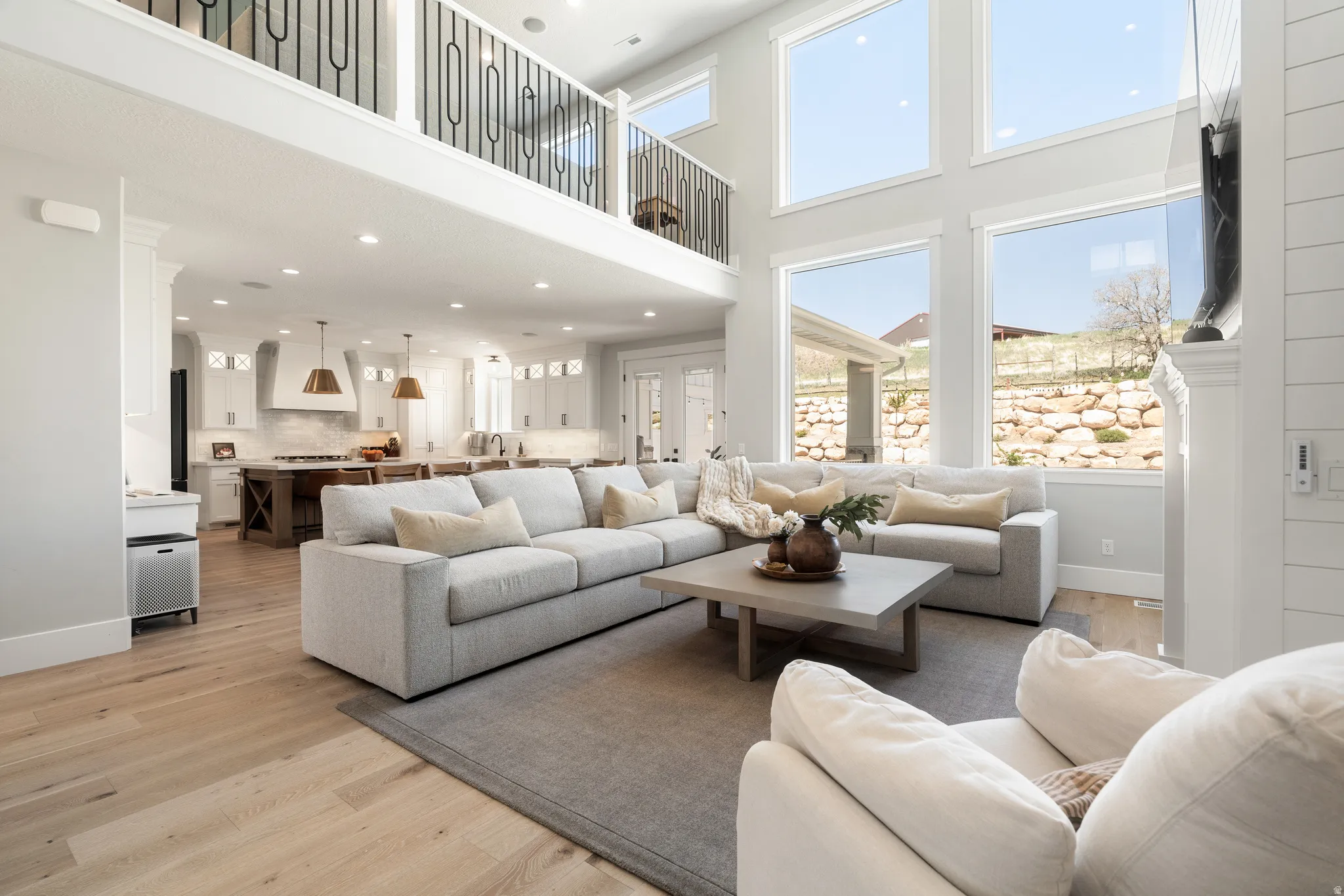 Living area featuring light wood-type flooring, recessed lighting, healthy amount of natural light, and a high ceiling