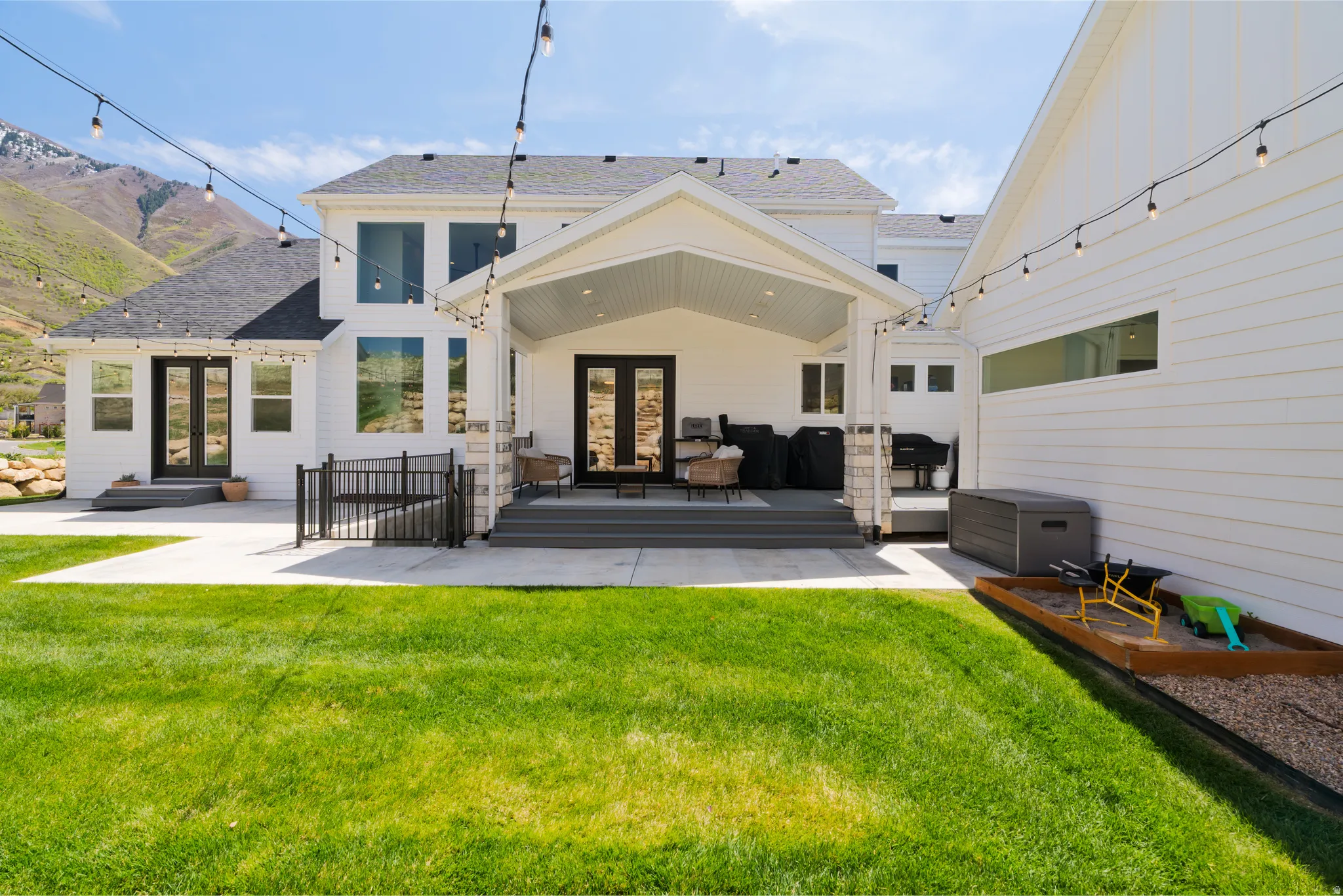 Rear view of property with french doors, a lawn, and a patio