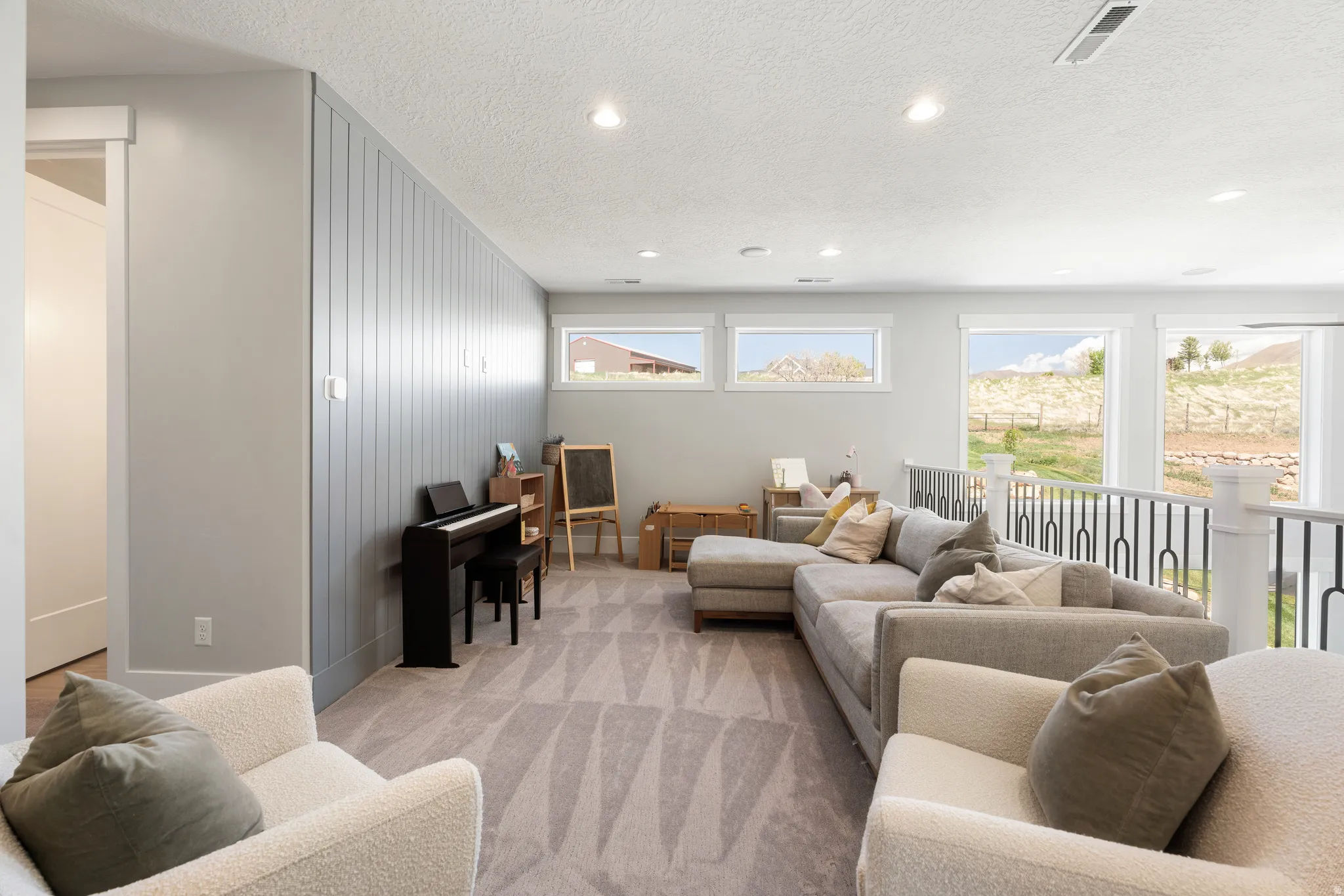 Living room featuring a textured ceiling, recessed lighting, and light colored carpet