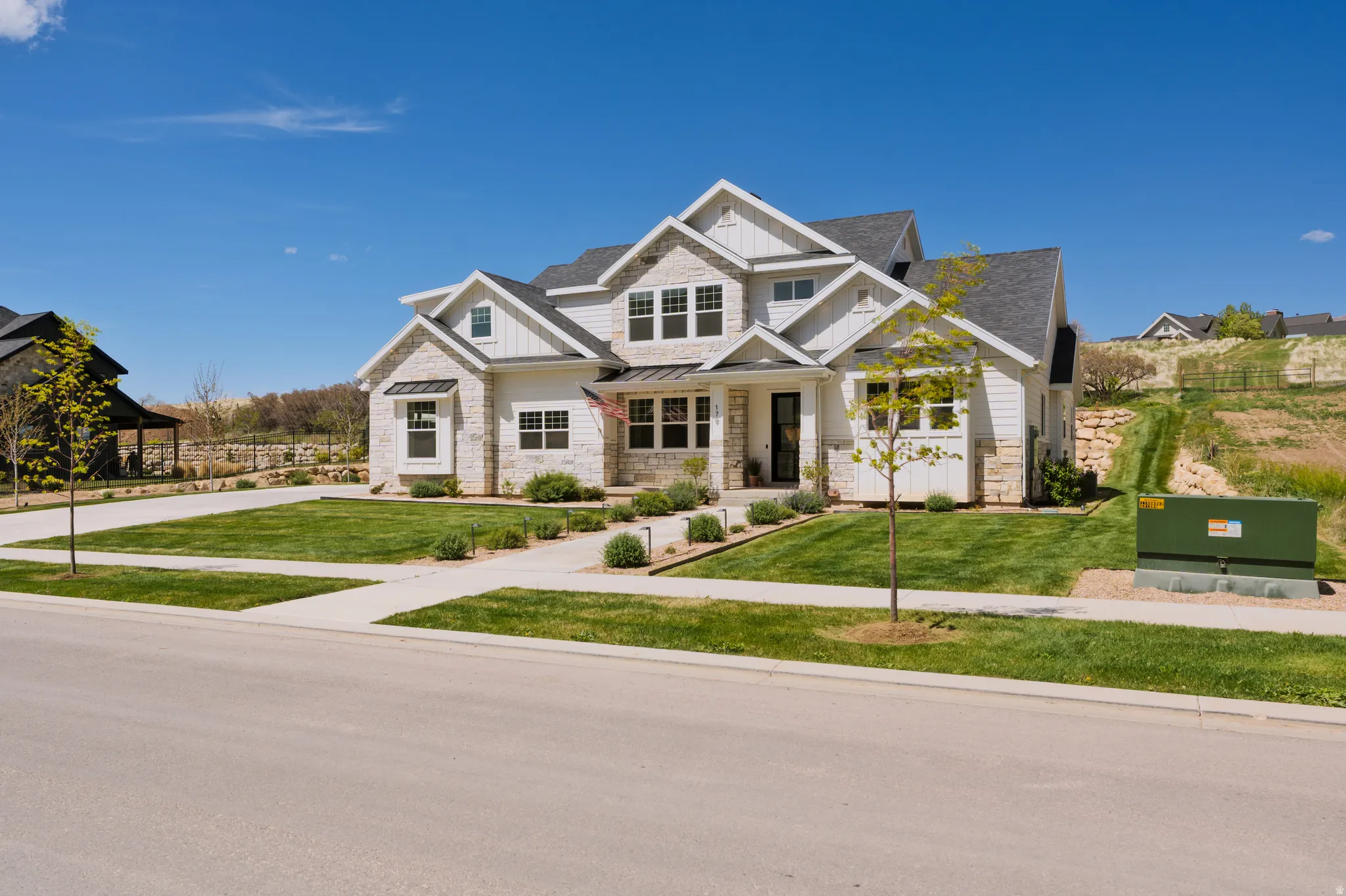 Craftsman-style house with a porch, board and batten siding, stone siding, and a standing seam roof