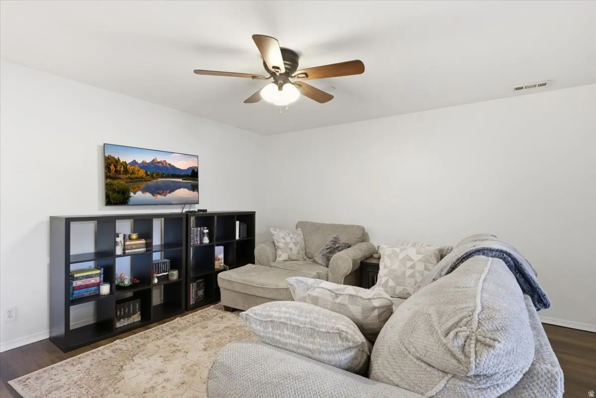 Living area featuring dark wood finished floors and ceiling fan