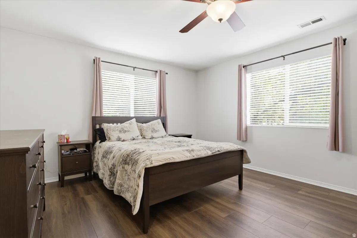 Bedroom with dark wood-style floors and a ceiling fan