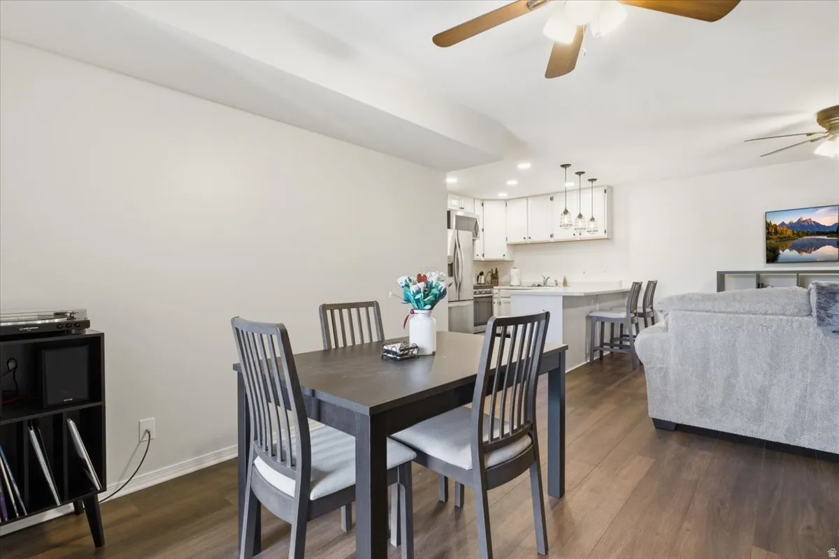 Dining space with dark wood finished floors, ceiling fan, and recessed lighting