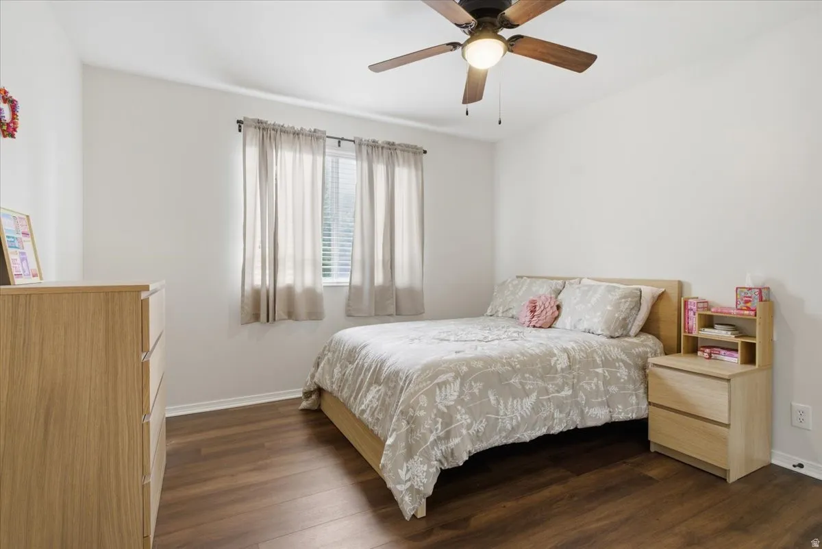 Bedroom with dark wood finished floors and a ceiling fan