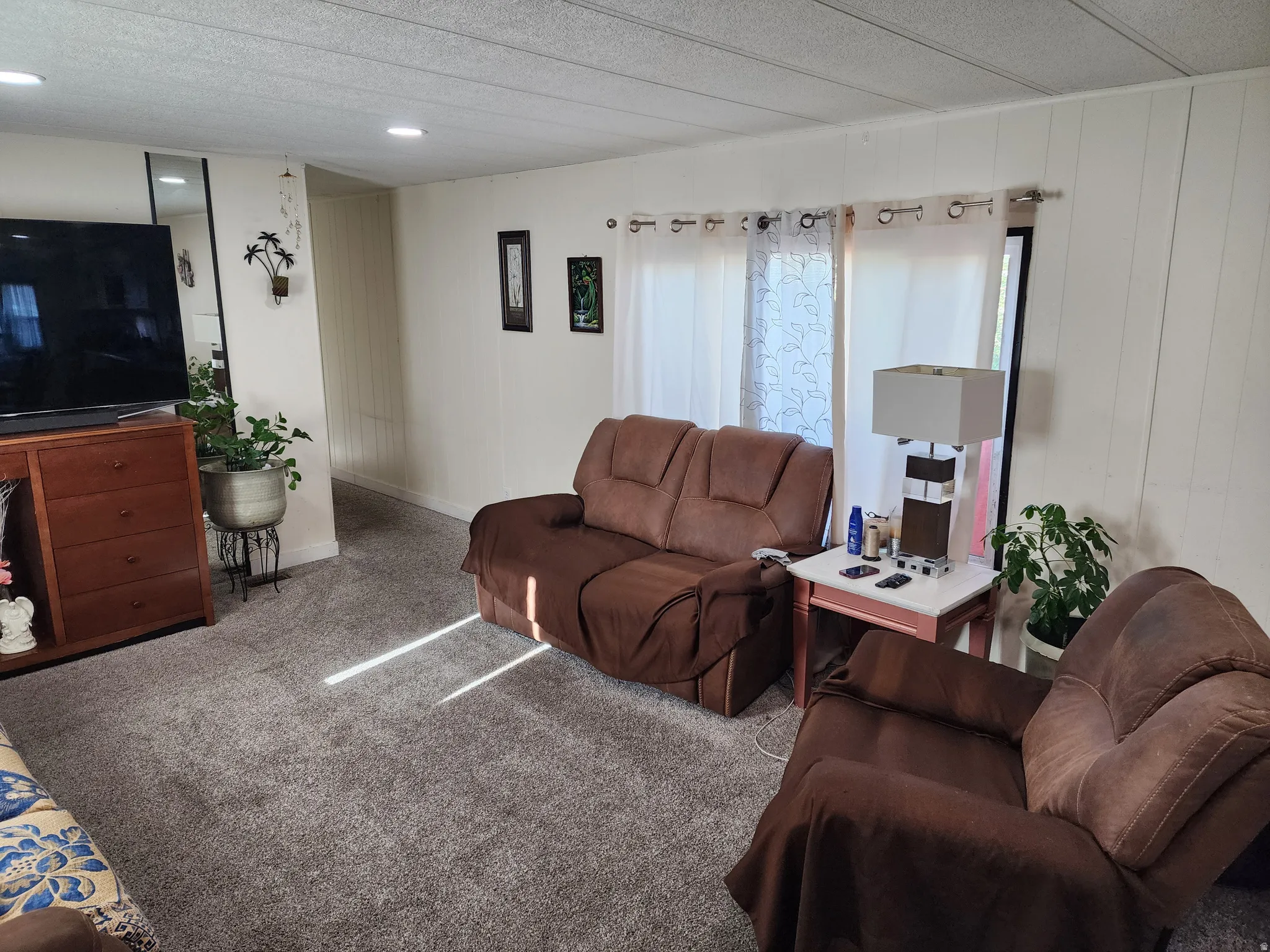 Carpeted living room with a textured ceiling